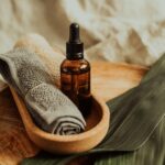 A soothing setup of skincare essentials featuring a dropper bottle, towel, and leafy backdrop, perfect for wellness inspiration.